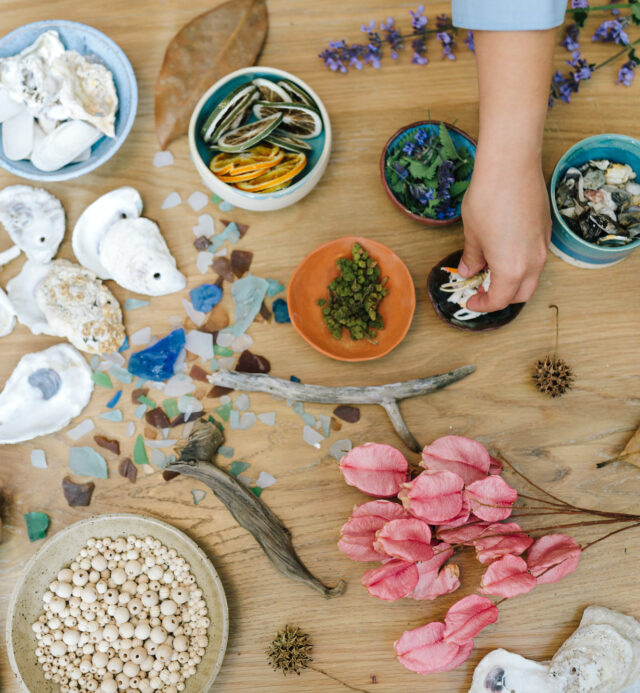table covered in various art supplies found in nature